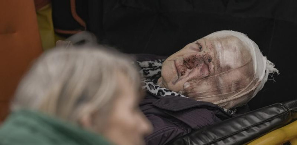 Una mujer herida evacuada de Irpín se ve en una camilla en una ambulancia a las afueras de Kiev, Ucrania, el sábado 26 de marzo de 2022. (AP Foto/Vadim Ghirda)