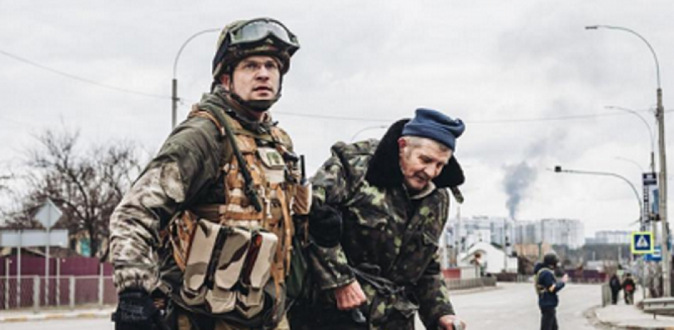 Un soldado ayuda a un anciano a escapar del bombardeo, a 6 de marzo de 2022, en Irpin (Ucrania). El alto el fuego que estaba previsto este domingo en la localidad ucraniana de Irpin para establecer un corredor humanitario ha fracasado.

Foto: Europa Press.