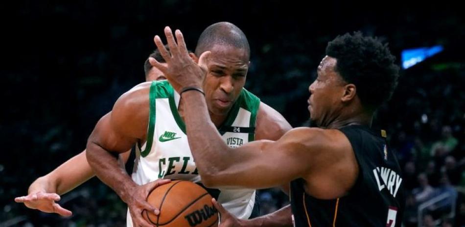 Al Horford, de los Celtics, sostiene el balón ante la cerrada defensa de Kyle Lowry, de los Heat, en acción del baloncesto de la NBA.