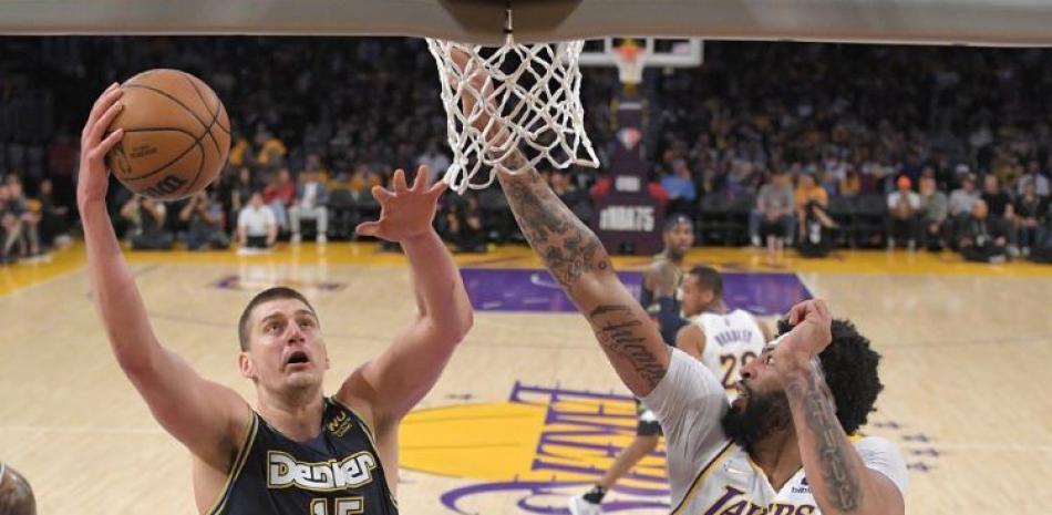 Nikola Jokic, izquierda, de los Nuggets de Denver, dispara ante la presión de Anthony Davis, de los Lakers de Los Ángeles.