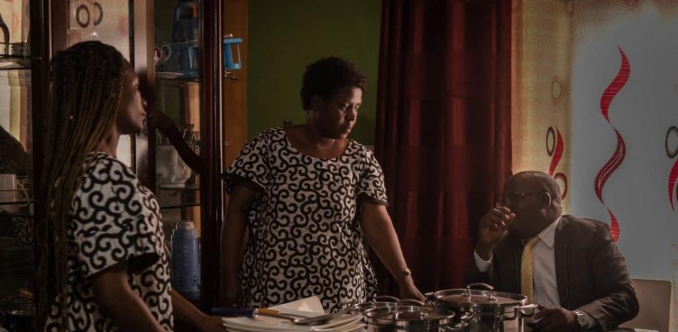 Chirhuza Zagabe, de 60 años, pastor de la Iglesia Primitiva del Señor, habla con dos de sus esposas en el salón de su casa antes de cenar. Foto: Guerchom Ndebo/AFP.