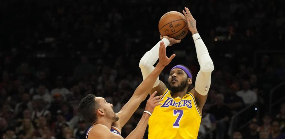 El jugador de los Lakers de Los Ángeles Carmelo Anthony (7) tira a canasta sobre el jugador de los Suns de Phoenix Landry Shamet durante su juego de la NBA.