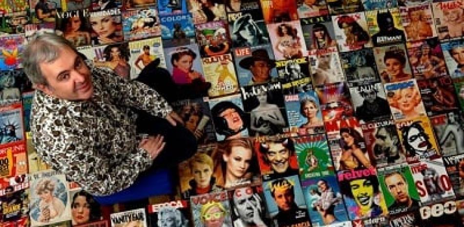 Fotografía cedida que muestra a Juan Cantafio mientras posa con la colección de portadas de revistas. EFE