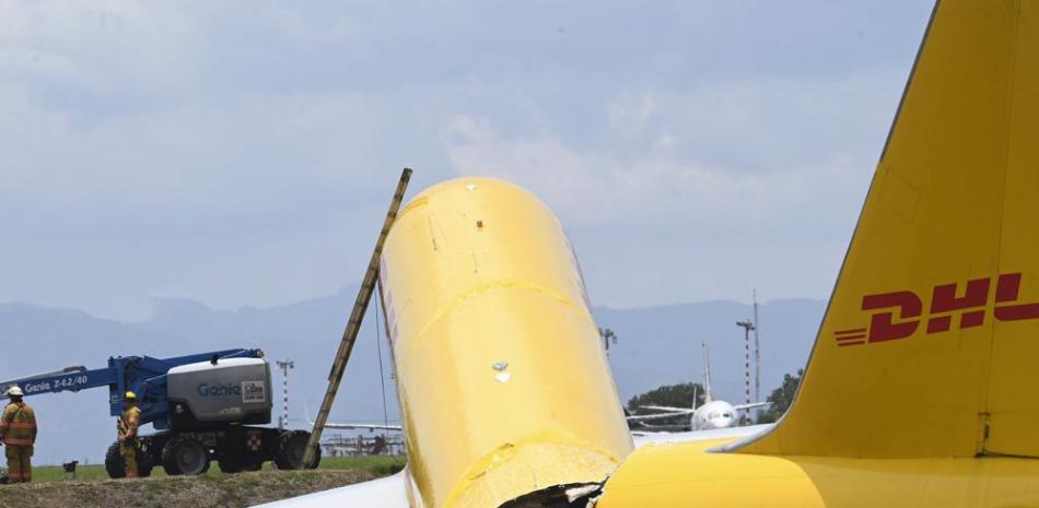 Un avión de carga que se desprendió yace roto en la pista del Aeropuerto Internacional Juan Santamaría en Alajuela, Costa Rica, el jueves 7 de abril de 2022. Según el departamento de bomberos, tanto el piloto como el copiloto se reportan en buen estado de salud. y accidente provocó el cierre total de la terminal aérea. (Foto AP/Carlos González)