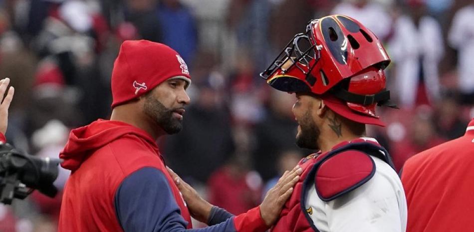 Albert Pujols y Yadier Molina comparten un saludo tras la victoria de los Cardenales de San Luis en el inicio del béisbol de las Grandes Ligas.
