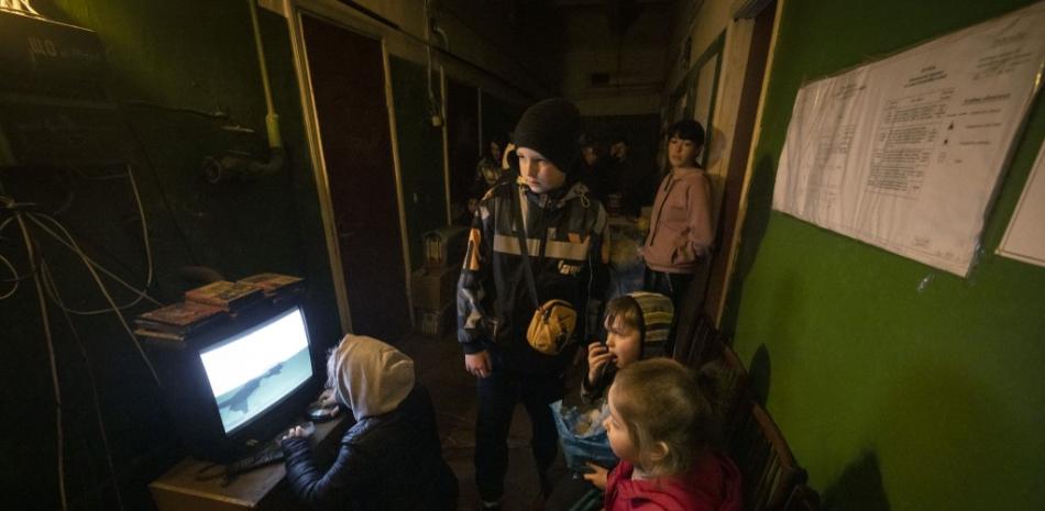 Niños ven un dibujo animado en una pantalla mientras los residentes se reúnen en un refugio en la ciudad de Severodonetsk, región de Donbass, el 6 de abril de 2022. Foto: Fadel Senna.