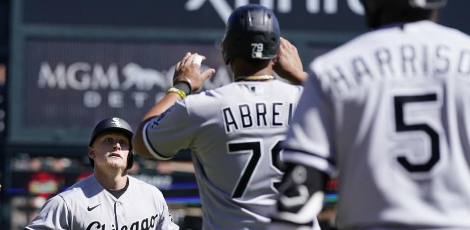 El bateador designado Andrew Vaughn (25) de los Medias Blancas de Chicago recibe el saludo de José Abreu tras conectar un jonrón ante los Tigres de Detroit.