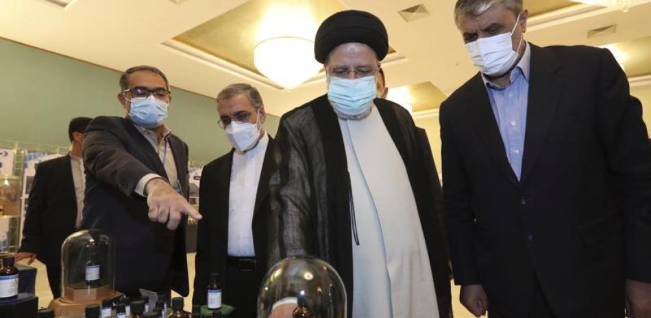 Fotografía proporcionada por el sitio web oficial de la presidencia iraní del presidente Ebrahim Raisi, segundo de la derecha, recibiendo una explicación mientras visita una exhibición de los logros nucleares de Irán en Teherán, Irán, el sábado 9 de abril de 2022. (Iranian Presidency Office vía AP)