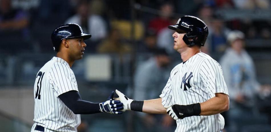 DJ LeMahieu (derecha) de los Yanquis de Nueva York, celebra con Aaron Hicks después de anotar ante los Azulejos de Toronto.