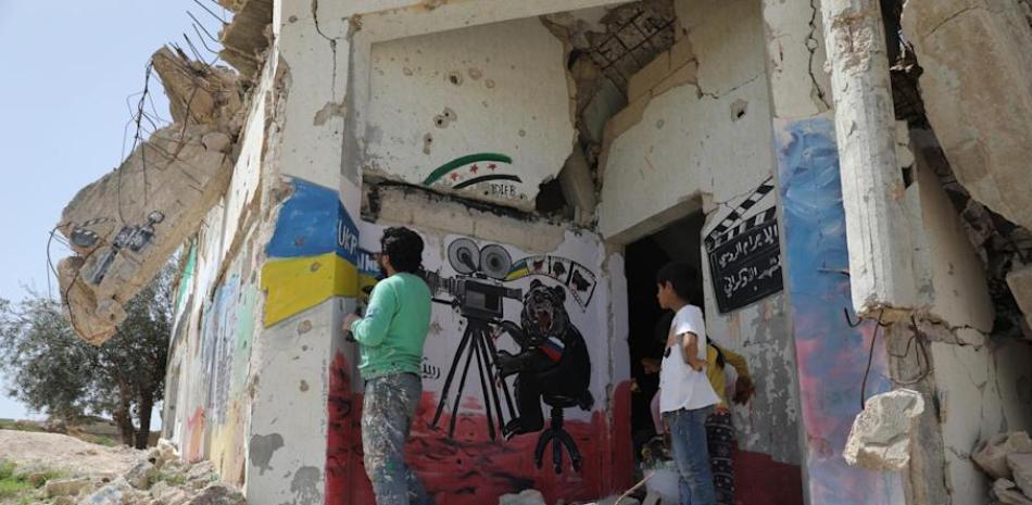 El artista sirio Aziz al-Asmar trabaja en un mural que representa un oso y colores ucranianos con una inscripción que dice en árabe (R) "Crimen ruso... escena ucraniana" en una pared en Idlib, Siria, el 11 de abril de 2022 (publicado el 13 de abril de 2022).

Foto: EFE/EPA/YAHYA NEMAH