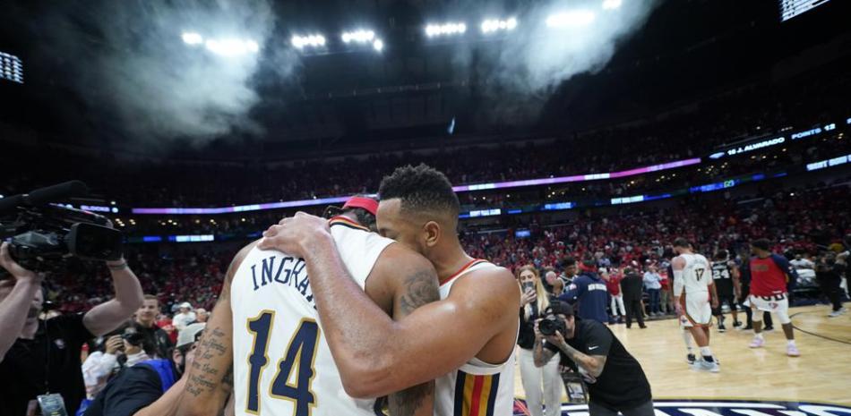 CJ McCollum, base de los Pelicans de Nueva Orleáns, abraza a su compañero Brandon Ingram (14) tras la victoria sobre los Spurs de San Antonio.