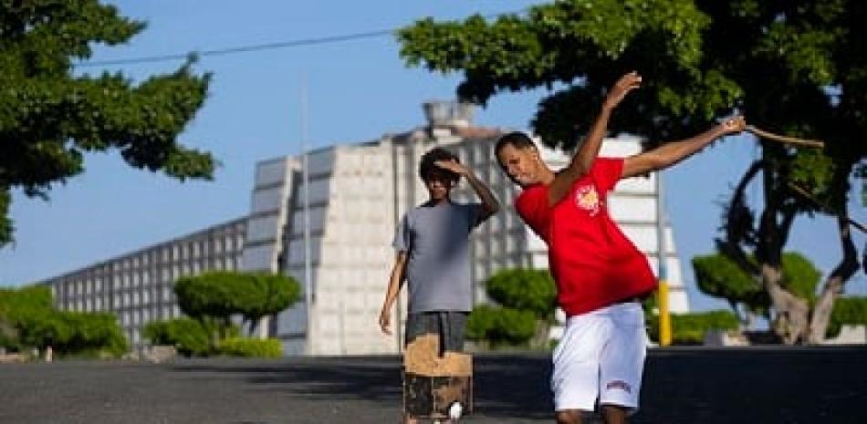 Un joven usa un palo de escoba en lugar del bate, durante un juego de vitilla, en medio de una calle de la barriada de Maquiteria, el 5 de abril de 2022. Orlando Barría / EFE