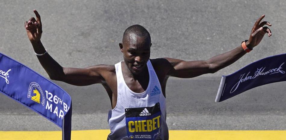 El keniano Evans Chebet levanta los brazos victorioso al cruzar la meta del Maratón de Boston.