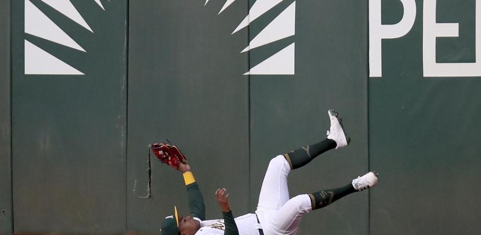Cristian Pache, de Oakland, cae al suelo tras atrapar una bola de Kelvin Gutiérrez, de Baltimore, en el segundo inning del juego de la MLB.