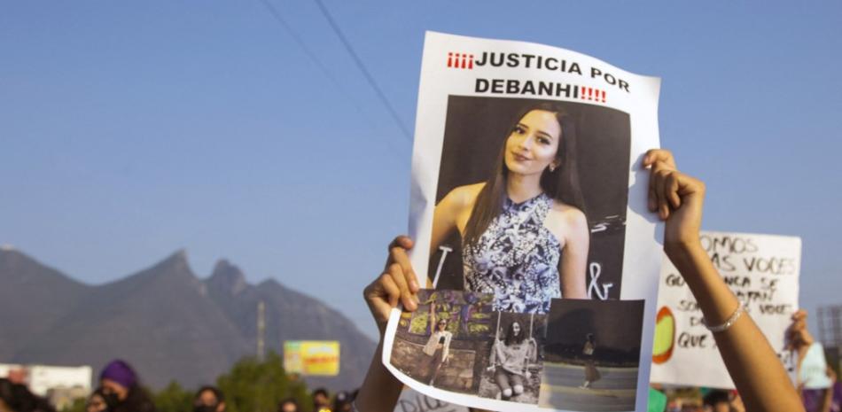 Personas sostienen carteles mientras participan en la marcha de mujeres exigiendo justicia para Debanhi Escobar, quien desapareció el 9 de abril y fue encontrada muerta ayer en el tanque de agua del motel Nueva Castilla, en Monterrey, estado de Nuevo León, el 22 de abril de 2022. Julio César AGUILAR / AFP