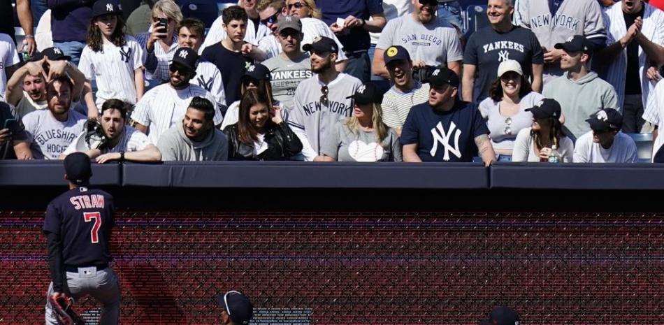 Myles Sraw jardinero de los Guardianes intercambia palabras con varios fanáticos de los Yankees en medio de una escena caótica.
