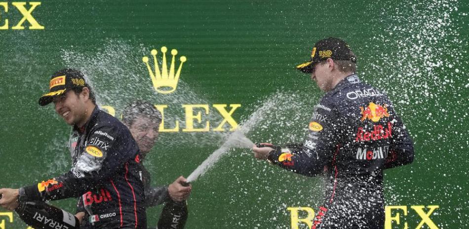 Los pilotos de Red Bull, Max Verstappen (derecha) y Sergio Pérez celebran en el podio luego de ganar el 1er y 2do lugar respectivamente en el Gran Premio de Emilia Romaña, el domingo 24 de abril de 2022, en Imola, Italia.