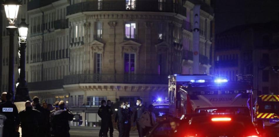 Los agentes de policía investigan el cuerpo de una de las dos personas a las que disparó la policía en París el 25 de abril de 2022. Poco después de la medianoche del domingo por la noche, la policía abrió fuego contra un automóvil que se negó a detenerse en un puesto de control policial en el Pont Neuf en París. La policía dijo a la AFP que el automóvil circulaba contra el tráfico y aceleró hacia los agentes, que se vieron obligados a abrir fuego, según la misma fuente policial. Ludovico MARIN / AFP