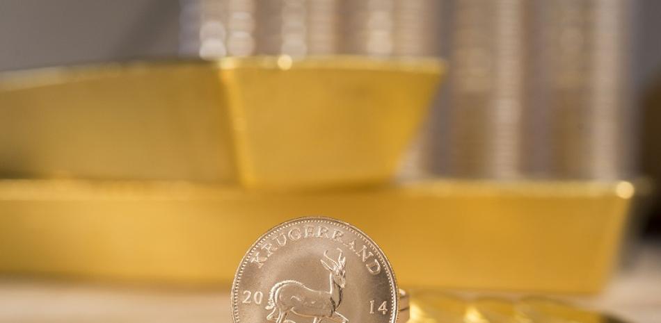 Dos lingotes y una moneda de oro. Foto: Coininvest.