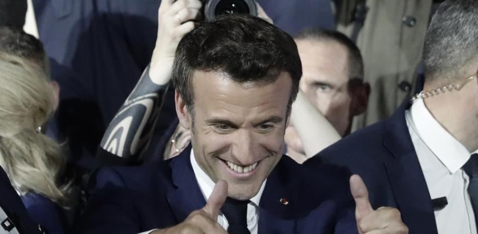 El presidente francés Emmanuel Macron celebra después de los reportes de su reelección, el domingo 24 de abril de 2022, en París. (AP Foto/Lewis Joly)