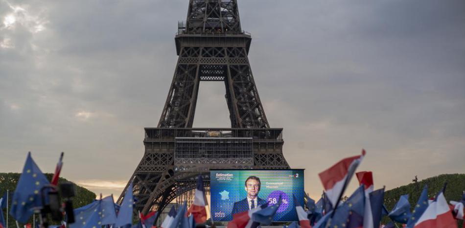 El presidente francés, Emmanuel Macron, celebra con simpatizantes frente a la Torre Eiffel París, Francia, el domingo 24 de abril de 2022. Las agencias de encuestas proyectaron que el presidente francés, Emmanuel Macron, ganó cómodamente la reelección el domingo en la segunda vuelta presidencial, ofreciendo tranquilidad a los votantes franceses y a la Unión Europea. de estabilidad de liderazgo en la única potencia con armas nucleares del bloque mientras el continente lidia con la invasión rusa de Ucrania. (Foto AP/Rafael Yaghobzadeh)