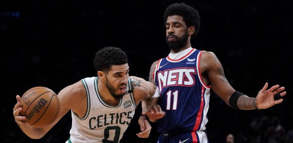El alero de los Celtics de Boston Jayson Tatum es defendido por el base de los Nets de Brooklyn Kyrie Irving, en la segunda mitad del cuarto juego de la serie de playoffs.
