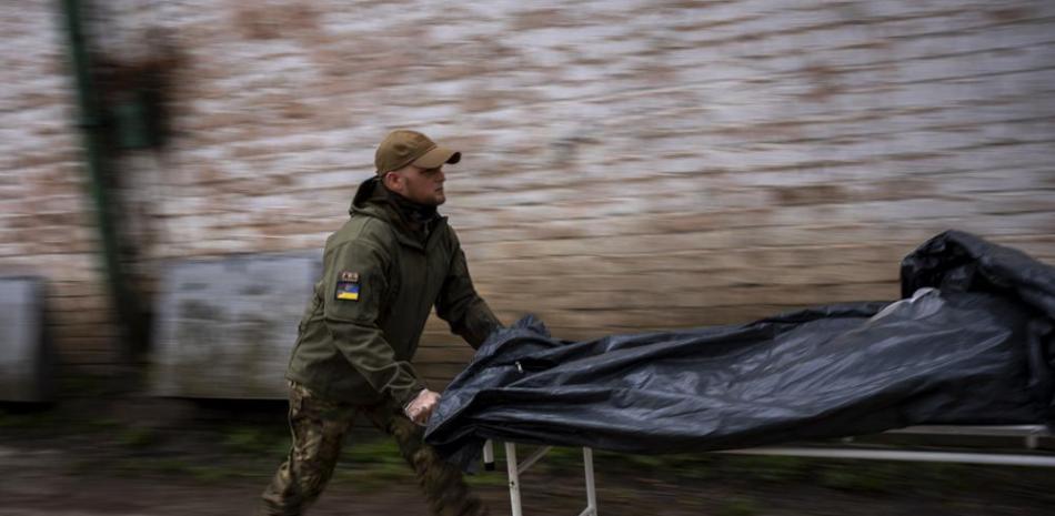 Darrell Loveless traslada cadáveres de los camiones refrigerados a la morgue en Bucha, en las afueras de Kiev, el lunes 25 de abril de 2022. (AP Foto/Emilio Morenatti)