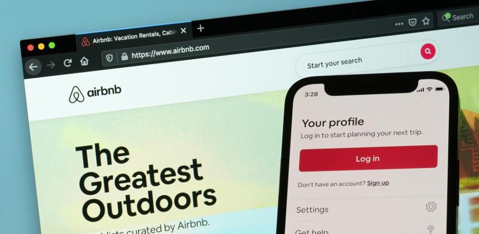 La página de inicio de sesión de la aplicación para iPhone de Airbnb se ve frente a una computadora que muestra el sitio web de Airbnb, el sábado 8 de mayo de 2021, en Washington. Airbnb está recibiendo un impulso del repunte de los viajes. La compañía de reservas de alojamiento dijo el martes 3 de mayo de 2022 que, si bien perdió $ 19 millones en el primer trimestre, eso fue mucho mejor que la pérdida de $ 1.2 mil millones que sufrió en el mismo trimestre del año anterior. Foto AP/Patrick Semansky, archivo
