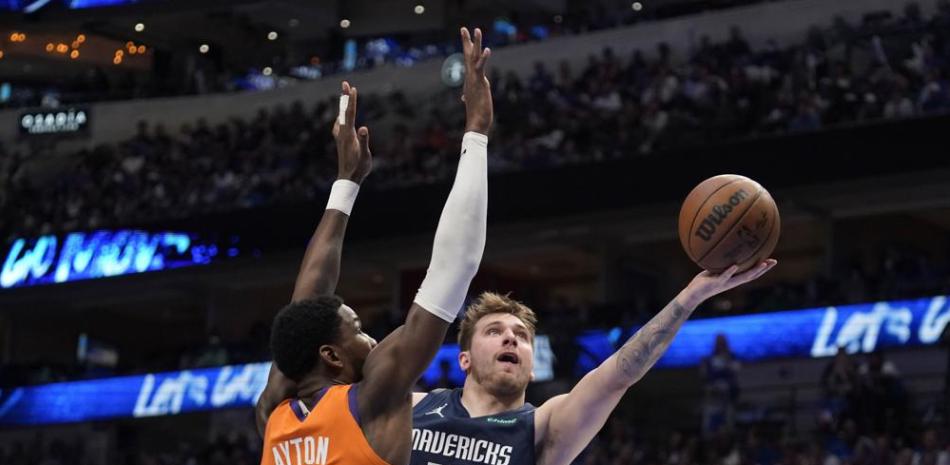 Luka Doncic (77) encesta por Dallas pese a la marca de Deandre Ayton (22), de los Suns, en el cuarto partido de la serie de segunda ronda de los playoffs de la NBA.