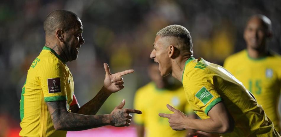El delantero brasileño Richarlison (derecha) festeja con su compañero Dani Alves tras anotar el cuarto gol ante Bolivia en el partido de la eliminatoria mundialista.