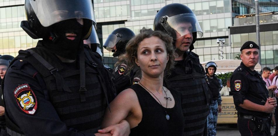 En esta foto de archivo tomada el 27 de julio de 2019, agentes de policía detienen a la activista política Maria Aliójina durante una concentración no autorizada que exigía que se permitiera a los candidatos independientes y de la oposición presentarse a las elecciones locales de septiembre, en la plaza Trubnaya de Moscú. Foto: Kirill Kudryavtsev/AFP.