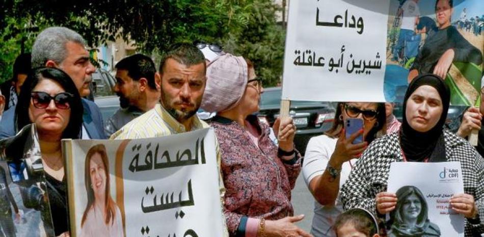 Personas portan carteles con el retrato de la veterana periodista palestina de Al-Jazeera Shireen Abu Akleh.