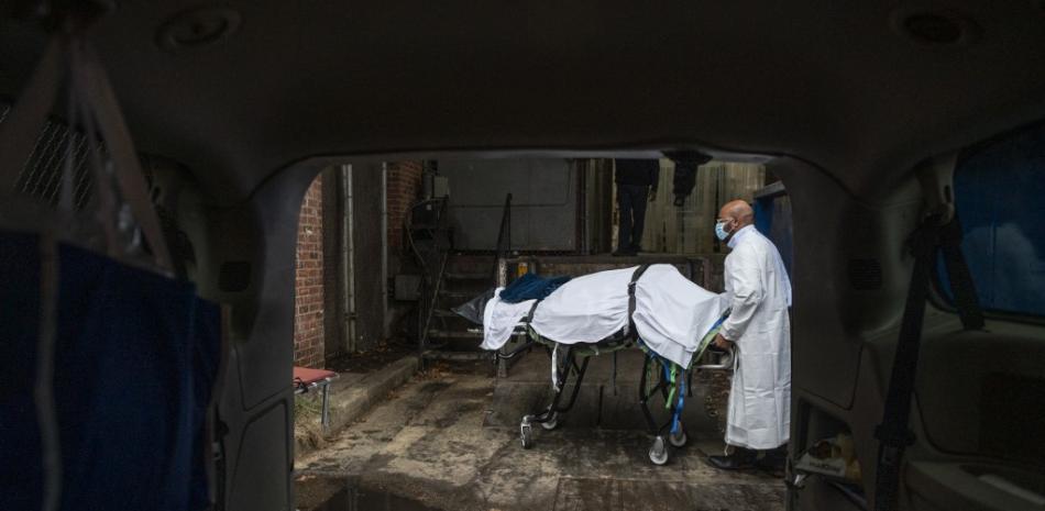 En esta foto de archivo tomada el 24 de diciembre de 2020, un transportista de Maryland Cremation Services, Reggie Elliott, lleva los restos de una víctima del Covid-19 a su furgoneta desde la morgue del hospital en Baltimore, Maryland, durante la pandemia del Covid-19. Foto: Andrew Caballero-Reynolds/AFP.