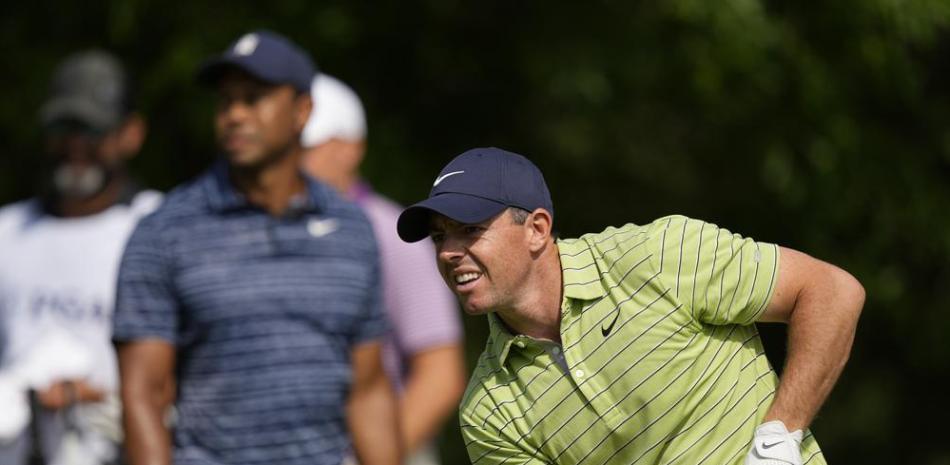 Rory McIlroy observa su tiro, delante de Tiger Woods, en la primera ronda del Campeonato de la PGA, en Tulsa, Oklahoma.