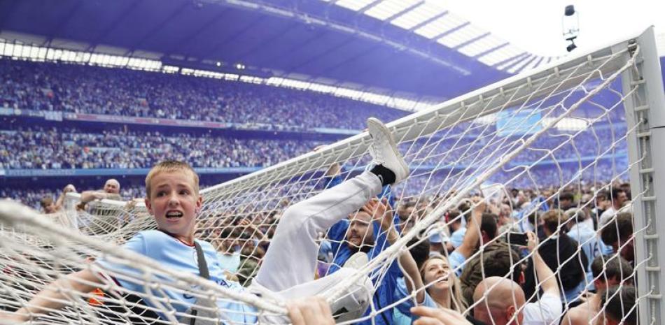 Los aficionados de Manchester City invaden la cancha luego de que el equipo venciera 3-2 al equipo de Aston Villa.