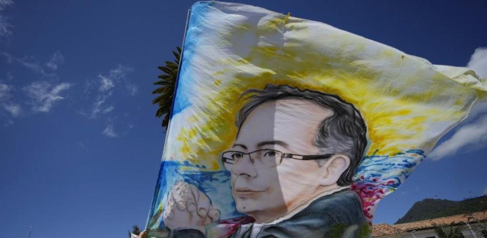 Un partidario del candidato presidencial Gustavo Petro sostiene una bandera con la imagen de Petro antes de un mitin de cierre de campaña en Zipaquirá, Colombia, el domingo 22 de mayo de 2022. Las elecciones están programadas para el 29 de mayo. (AP Foto/Fernando Vergara)