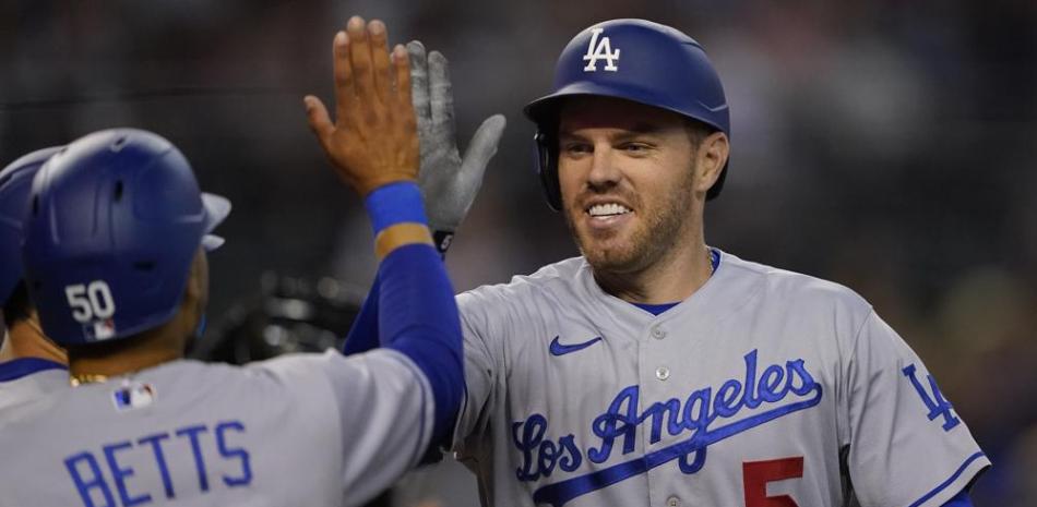 Freddie Freeman (5), de los Dodgers de Los Ángeles, choca la mano de Mookie Betts (50) tras conectar un jonrón de tres carreras ante los Diamondbacks de Arizona.