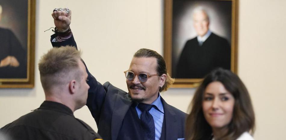 El actor Johnny Depp hace un gesto a los espectadores en la corte después de los argumentos finales en el juzgado de circuito del condado de Fairfax en Fairfax, Virginia, el viernes 27 de mayo de 2022. (Foto AP/Steve Helber, Piscina)