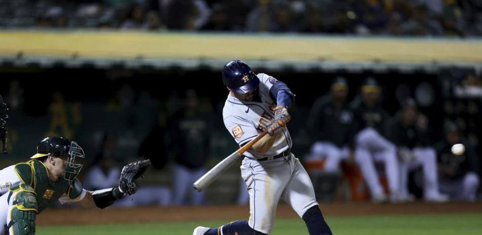 El jugador de los Astros de Houston Chas McCormick pega un jonrón ante el catcher de los Atléticos de Oakland Sean Murphy, en el octavo inning.