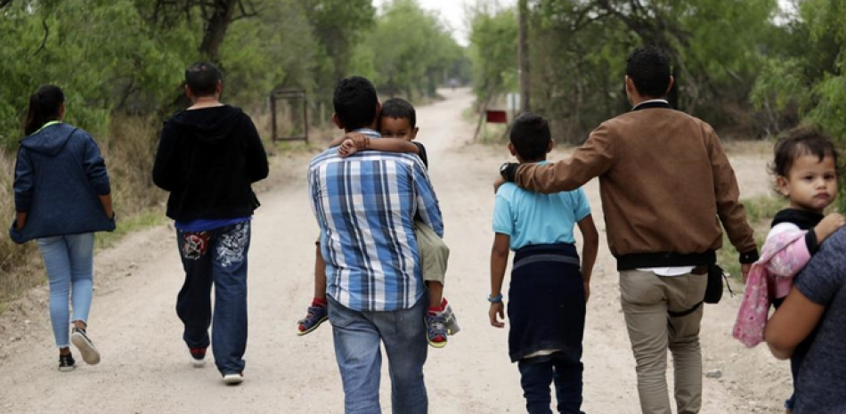 Un grupo de familias migrantes camina desde el Río Grande, el río que separa Estados Unidos y México en Texas, cerca de McAllen, Texas, el 14 de marzo de 2019. AP