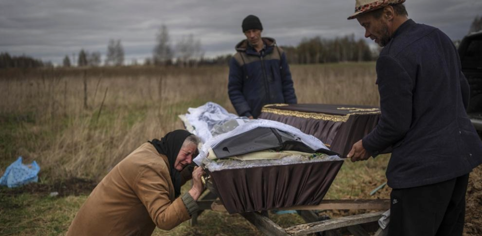 Nadiya Trubchaninova llora sobre el ataúd de su hijo, Vadym, asesinado el 30 de marzo por soldados rusos en Bucha, Ucrania, durante su funeral en Mykulychi, Kyiv. AP