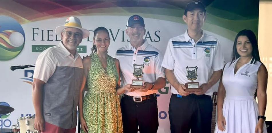 Los grandes campeones del Torneo Fiebre de Vistas reciben sus trofeos. Desde la izquierda, Felix Olivo, Maité Camasta de Olivo, Alexis Dumé, Andrés Choi, y la modelo Dewar’s.