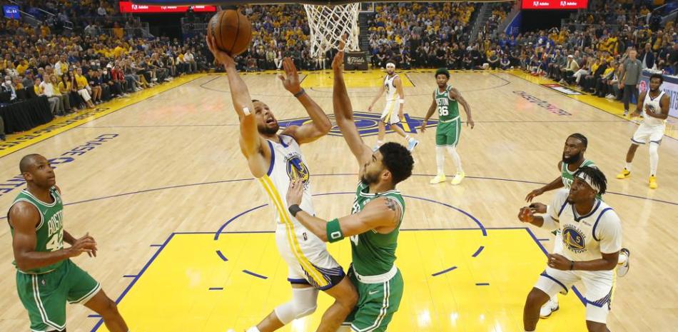 Stephen Curry, de los Warriors de Golden State, ataca la canasta con la marca de Jayson Tatum, de los Celtics de Boston, durante la primera mitad del Juego 2 de las Finales de la NBA, en San Francisco.
