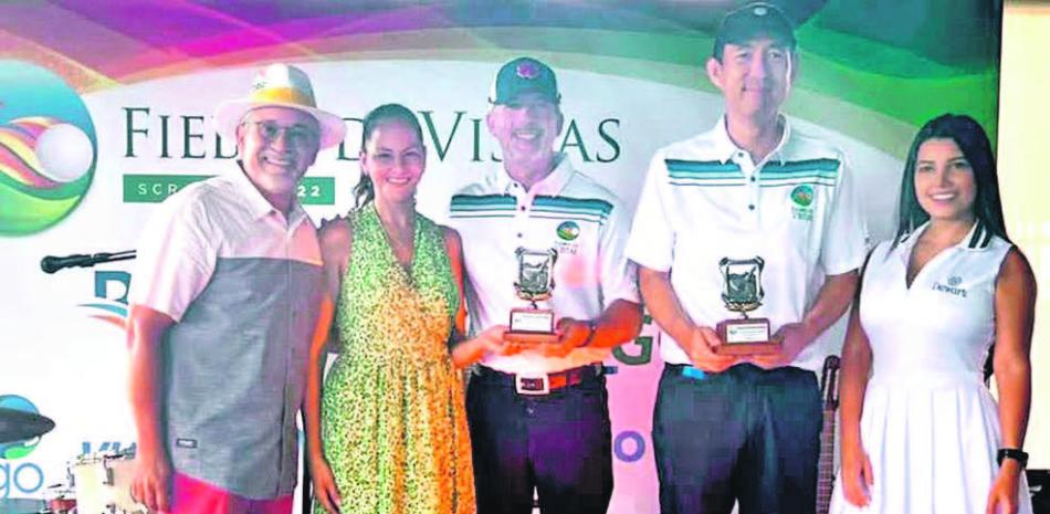 Los grandes campeones del Torneo Fiebre de Vistas reciben sus trofeos. Desde la izquierda, Felix Olivo, Maité Camasta de Olivo, Alexis Dumé, Andrés Choi, y la modelo Dewar’s.