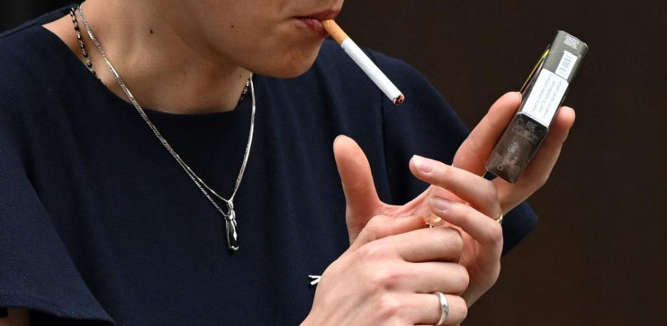 Se ve a una mujer fumando un cigarrillo en el centro de Londres el 9 de junio de 2022. La edad a la que las personas pueden comprar tabaco en Inglaterra debería aumentar en uno cada año hasta que se convierta en una sociedad "libre de humo", recomendó el jueves una revisión encargada por el gobierno. .

Foto: JUSTIN TALLIS / AFP