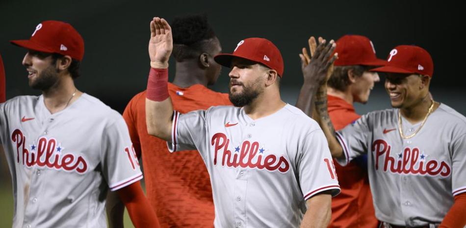 Kyle Schwarber (centro) festeja con el resto de los Filis de Filadelia la paliza sobre los Nacionales de Washington.