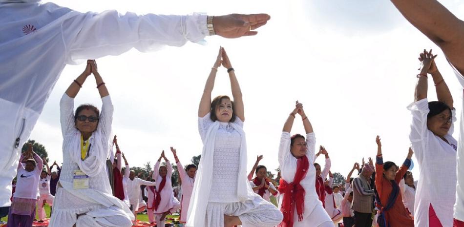 Un grupo de personas practica yoga para conmemorar el Día Internacional del Yoga, en Katmandú, Nepal. Foto AP