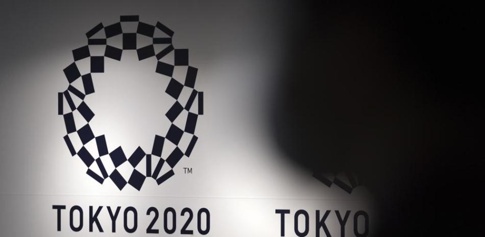 Una persona pasa frente al logo de Tokio 2020 en el Aeropuerto de Haneda, Tokio, 14 de junio de 2021.