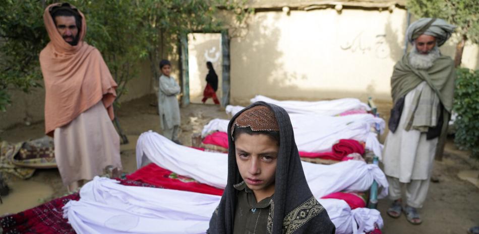 Varias personas esperan junto a los cadáveres de personas fallecidas en un sismo, en la localidad de Gayan, en la provincia de Paktiká, Afganistán, el 23 de junio de 2022. Foto: AP/Ebrahim Nooroozi