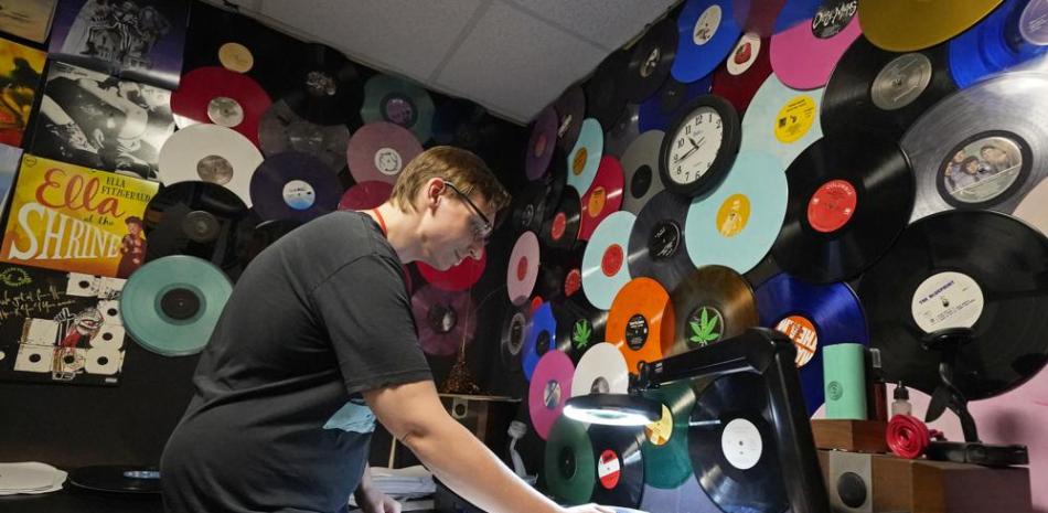 Tyler Bryant escucha discos de vinilo terminados en busca de fallas, en una sala de control de calidad en las instalaciones de United Record Pressing, el jueves 23 de junio de 2022 en Nashville, Tennessee. (Foto AP/Mark Humphrey).